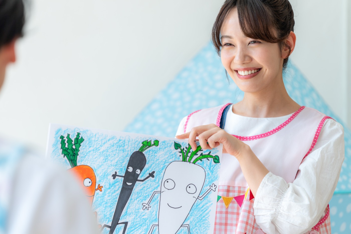 園児に絵本を見せる保育士（イメージ）